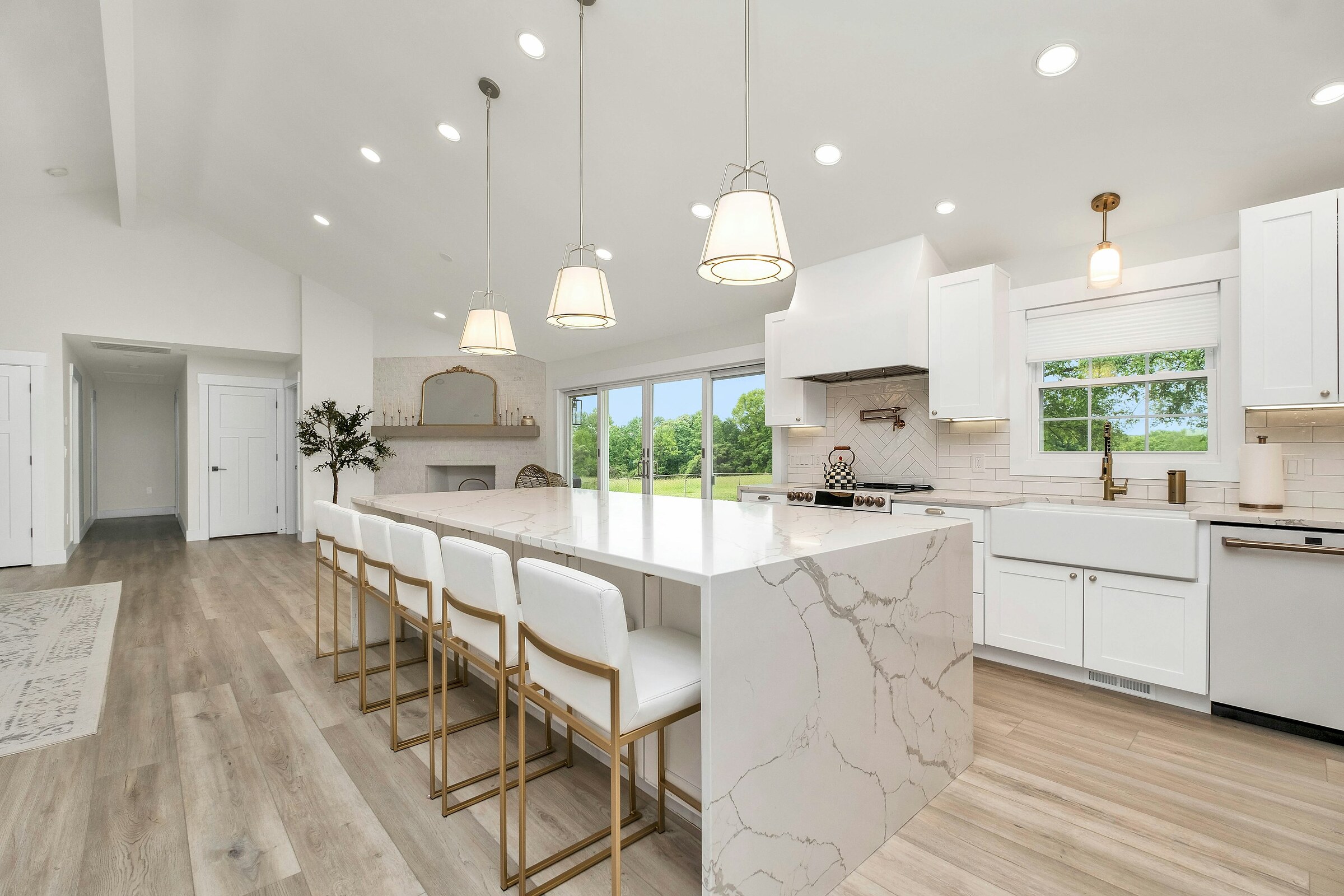 Premium quartz waterfall countertop with custom cabinetry and designer fixtures in a luxury kitchen